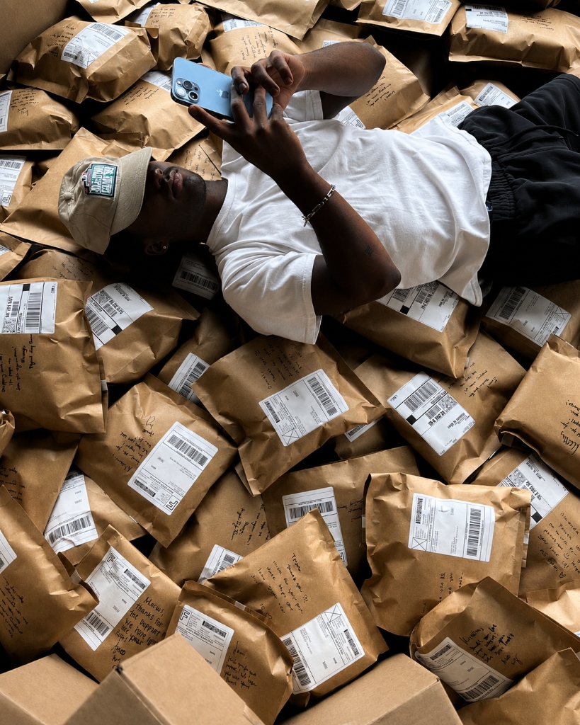 Person looking at phone surrounded by packages
