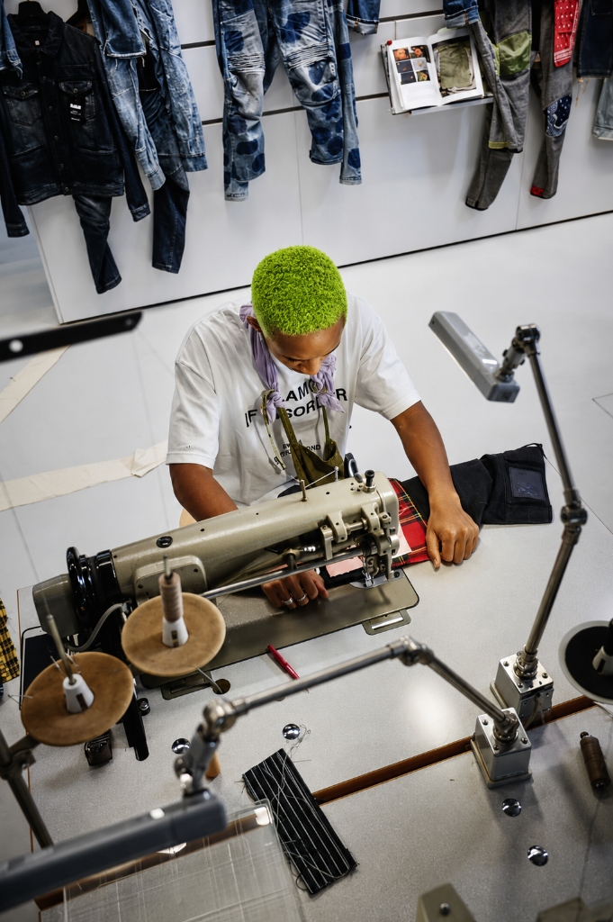Winner Oyebanjo tailoring on sewing machine